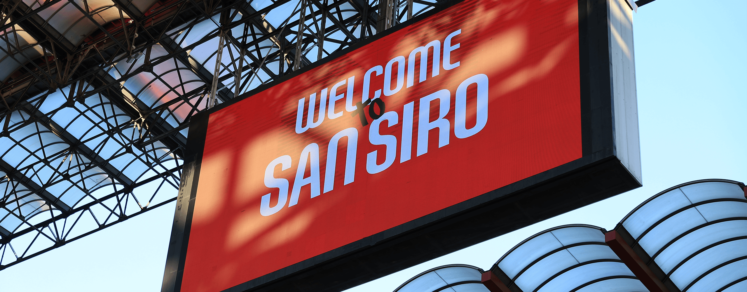 Maxi schermo rosso con scritta ‘Welcome to San Siro’ e struttura di copertura dello stadio